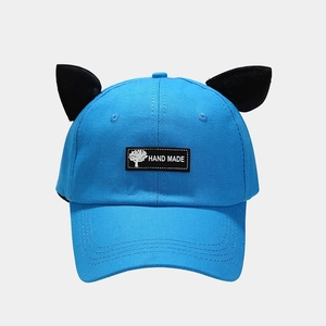 Close-up of blue cotton baseball cap with cute black plush cat ears and handmade label