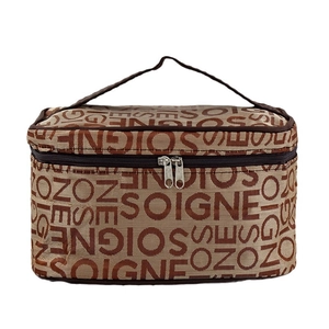 Brown monogrammed cosmetic bag with top handle and full zipper closure in studio lighting