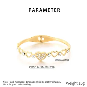 Detailed macro view of gold hollow heart-shaped stainless steel bangle with white zircons