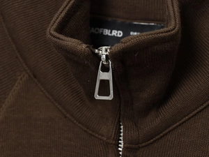 Close-up of high-quality silver metal zipper on a brown ribbed knit fashion sweatshirt
