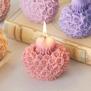 Detail of multi-colored rose bouquet candles with heart accents on vintage books