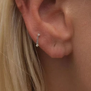 Close-up of heart and butterfly stackable cartilage studs with sparkling gemstones