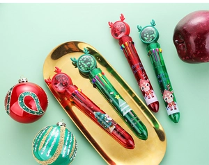 Close-up of Christmas 10-color ballpoint pens with sequin reindeer ball and festive decor