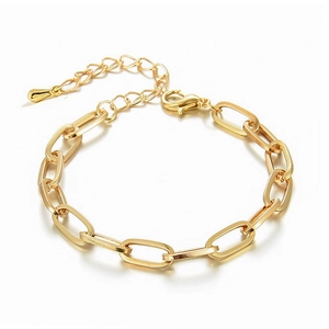 Detailed view of golden paperclip chain bracelet with lobster clasp and teardrop charm