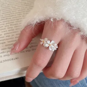 Silver flower open ring featuring three delicate daisy petals with gold-tone centers