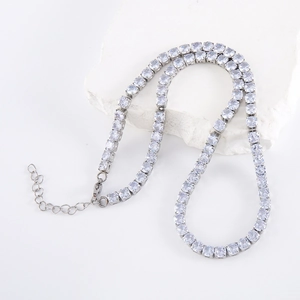 Détail macro du collier tennis argenté avec oxydes de zirconium sur décor minéral