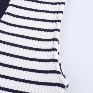 Detailed macro view showing the high-quality stitching on the black and white ribbed fabric