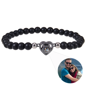 Detail of heart projection bracelet with black matte beads and custom photo magnification
