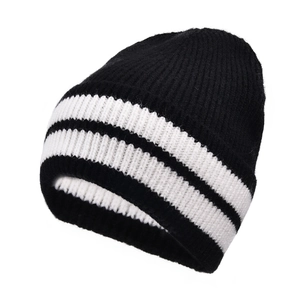 Detailed close-up of thick ribbed knit texture on black and white striped wool beanie