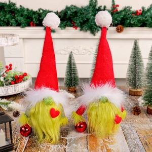 Christmas faceless gnome dolls with red hearts and green beards on snowy wood floor