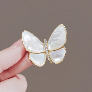 Broche papillon élégante en nacre blanche avec pierres de zircon et bordure dorée