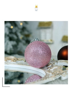 Close-up of pink glitter Christmas ball ornament with silver cap on mirror tray