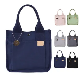 Borsa a mano in tela multitasche con bottone a pressione in metallo e logo del brand