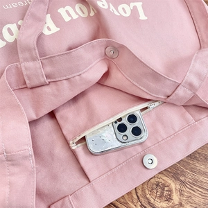 Detail of pink canvas tote showing interior pocket zipper and magnetic snap closure