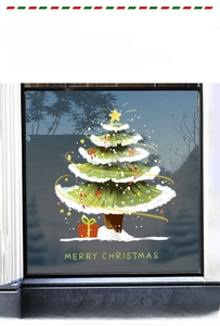 Détail d'un autocollant de sapin de Noël vert avec texte de vœux sur une vitre en verre