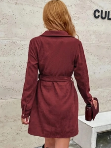 Detail of burgundy corduroy shirt dress fabric texture and elegant back tailoring