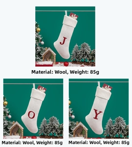 Detail of white knitted Christmas stockings with red JOY letters, weighing 85g each