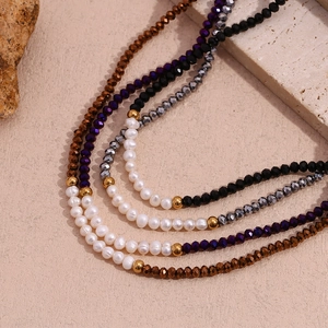 Macro detail of handmade necklace featuring freshwater pearls and multi-color faceted beads