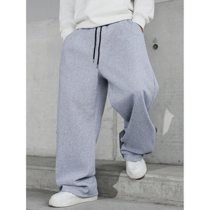 Detail of light gray sweatpants featuring black double drawstrings and knit texture
