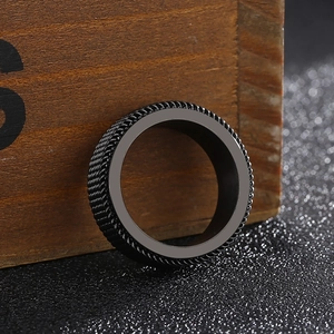 Macro detail of men's black rotatable titanium steel ring with chain texture finish