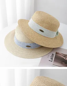 Detailed macro view of woven boater hats with elegant blue ribbon and metal logo plate