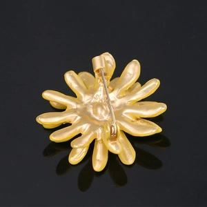 Close-up of the yellow daisy brooch back showing the pin mechanism and metal detail