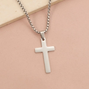 Polished silver stainless steel cross pendant necklace with box chain on stone background