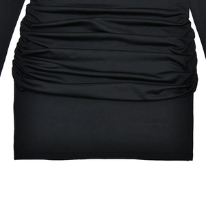 Detailed close-up showing textured ruching and smooth stretch fabric on black mini dress