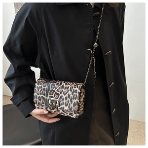 Close-up of leopard print shoulder bag featuring metal chain strap and square buckle