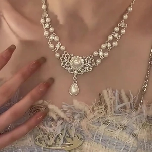 Close-up of baroque pearl necklace with crystal pendant on double-layer silver chain