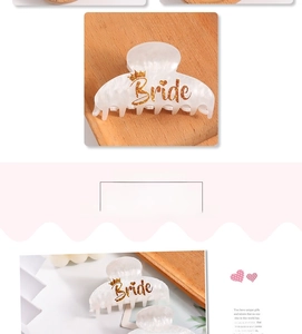 Close-up of marble white hair claw with golden Bride lettering and crown detail
