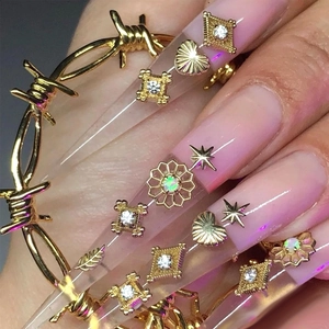Ciondoli dorati per nail art a forma di cuore e stella su unghie finte rosa