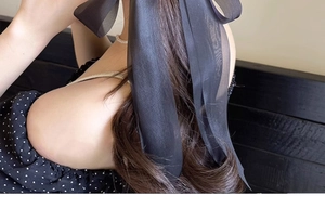 Detail of elegant black oversized chiffon bow hair clip with long ribbons on low ponytail