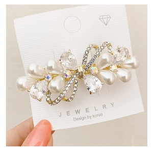 Close-up of butterfly crystal hair clip with baroque pearls and gold-tone finish