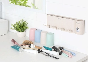 Dettaglio del portaspazzolino a parete con dispenser e quattro bicchieri colorati