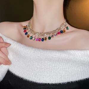Gros plan d'un mannequin portant un collier à franges dorées et pierres colorées