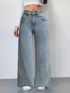 Detail van high waisted jeans met wijde pijpen in vintage wassing blauw en denim