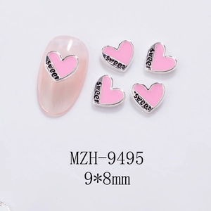 Detail of pink heart nail charms with sweet engraving and silver metal borders