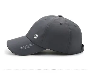 Detailed side view of dark grey quick-dry baseball cap with M embroidery and sport text