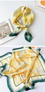 Close-up of elegant silk-like square scarf with yellow floral patterns and green borders