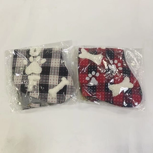 Detail view of plaid Christmas stockings with plush bone accents in clear packaging