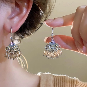 Primo piano di orecchini a forma di conchiglia con perline champagne e strass brillanti