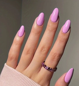 Close-up of glossy light purple almond press-on nails with matching gemstone ring
