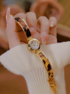 Close-up of a women's vintage tortoise shell chain bracelet watch with gold case