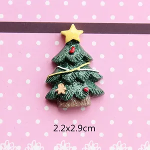 Detail view of a 2.2x2.9cm green glitter Christmas tree resin charm with a gingerbread man