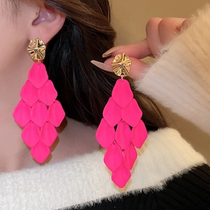 Close-up of pink acrylic petal tassel earrings on a model showing tiered floral design