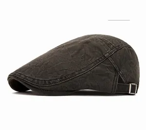 Detail of olive green vintage flat cap showing washed cotton texture and metal side buckle