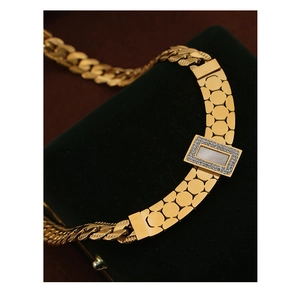 Detailed close-up of gold-plated pendant with white shell and sparkling rhinestones