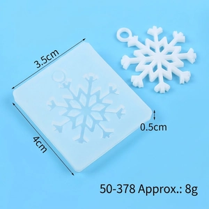 Macro view of snowflake silicone mold and finished resin pendant on blue background