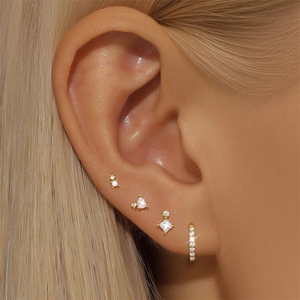 Detailed view of four-piece S925 silver gold earrings set with sparkling zircons